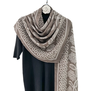 Ethnic style dark brown printed shawl with white lace flower pattern on a black mannequin