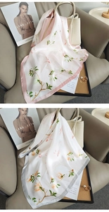 Vue détaillée de foulards en soie floraux rose et gris drapés sur un sac à main beige