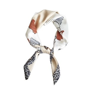 Satin neck scarf with orange polka dots and leopard print trim in an elegant knot style