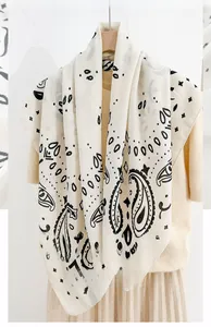 Detail of 90x90cm square scarf with black herringbone and paisley prints on beige fabric