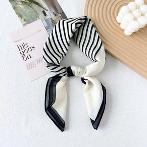 French chic style black and white striped silk scarf tied and styled on a white tray