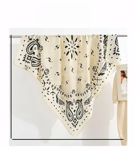 Detail of 90x90cm cream paisley square scarf featuring black geometric patterns and stars