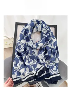 Detail shot of blue and white floral scarf with navy stripes and a refined finish
