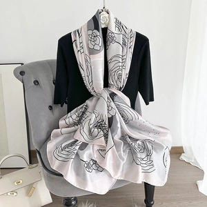 Detailed view of silk satin shawl featuring elegant black line rose prints on pink fabric