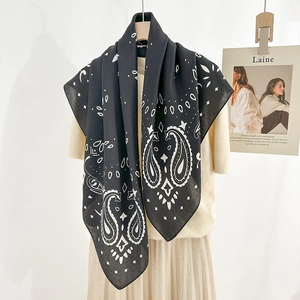 Classic black paisley printed square scarf styled on beige outfit for elegant spring look