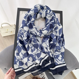 Lightweight cotton linen scarf with blue floral pattern and striped edges as a shawl