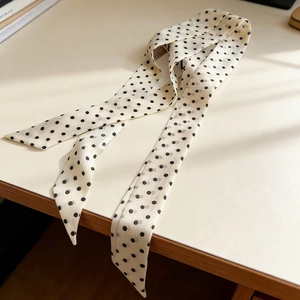 Polka dot 100% mulberry silk narrow scarf shown at 45-degree angle on a desk