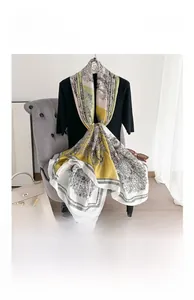 Macro detail of elegant paisley silk satin long scarf styled with a luxury handbag