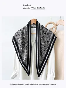 Detail of black and white paisley silk scarf tied on a white shirt with faux silk texture