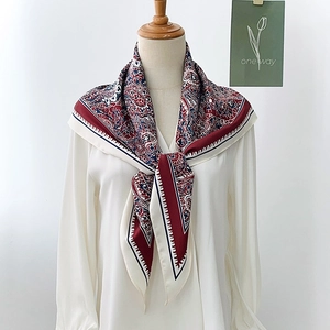 Close-up of elegant Paisley silk scarf featuring vintage red and navy ethnic patterns