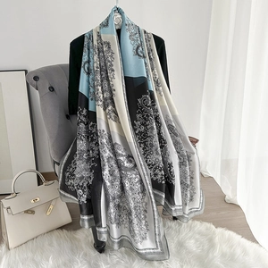 Detail of silk-like paisley shawl with blue and white baroque patterns on a sofa