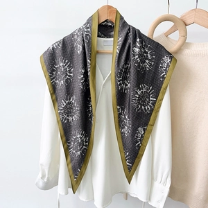 Foulard triangolare grigio scuro con stampa floreale e bordo oliva su camicia bianca
