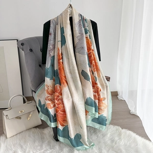 Close-up of elegant silk scarf with floral print draped over a chair and black top
