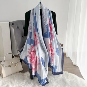 Detailed view of light blue silk scarf with lotus print draped on a chair