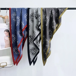 Versatili foulard in raso con stampa floreale in blu, grigio e marrone su un rack