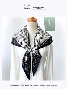 Detail of black and white polka dot scarf showing faux velvet fabric texture on mannequin