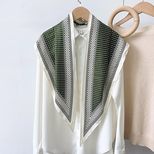 Close-up of dark green and white polka dot silk scarf with elegant contrast borders