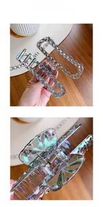 Macro detail of large iridescent shark hair claw clip with geometric faceted texture