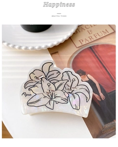 Detalle de la pinza para el pelo de acetato blanco con diseño floral y cristales finos