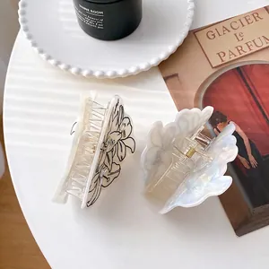 Elegantes pinzas para el cabello con flores de acetato en blanco y negro en bandeja