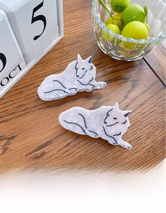 Close-up of wolf-shaped acetate hair claw clips with marble texture on a wooden desk
