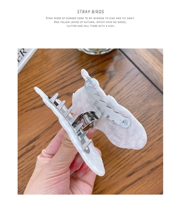 Detailed close-up of marble pattern hair claw clip with strong metal spring mechanism