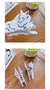 Detailed view of wolf-shaped acetate hair claw with white marble texture and metal spring