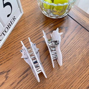 Cat shape hair claw clip set with pink marble texture and metal spring on wood table