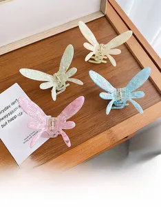 Détail de pinces à cheveux papillon en acétate aux tons pastels sur un plateau