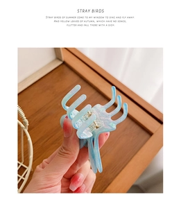 Détail de la pince à cheveux en acétate marbré bleu clair avec finition nacrée