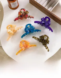 Detailed overhead view of six assorted acetate bow hair claws in vibrant colors and patterns