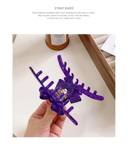 Detailed view of a purple acetate hair claw clip with a bow and elk antler design