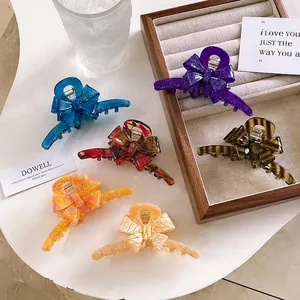 Elegant acetate bow hair claws in six colors including marble and tortoiseshell patterns
