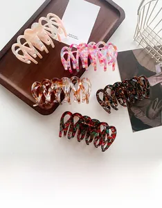 Detailed close-up of large acetate claw clips in various elegant marble patterns