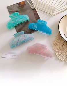 Vista dall'alto di grandi mollette per capelli in acetato colorato con motivi marmorizzati