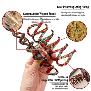 Large acetate hair claw clip with artistic red and green patterns and gold spring
