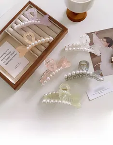 Macro shot of assorted colorful acetate hair claws with white pearl accents and metal spring