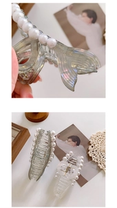 Detailed view of elegant fishtail shark clips with embedded pearls on transparent material