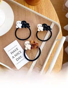 Detailed close-up of cute dog-shaped acetate hair ties on a wooden tabletop tray