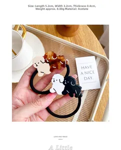 Hand holding acetate dog hair tie showing dimensions of 5.2cm length and 3.2cm width