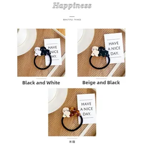 Detail of high-elasticity hair ties with cute acetate dog charms in three color options