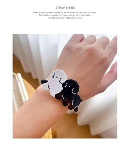 Close-up of cute black and white acetate dog charms on high elastic hair ties