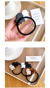 Detailed view of acetate puppy hair ties in black, white, apricot, and tortoiseshell patterns