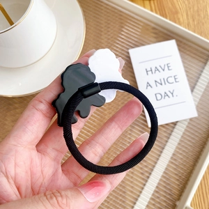 Cute black and white acetate dog hair tie on high-elastic rope with a cozy home setting