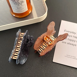 Elegant butterfly hair claws in blue marble and amber finishes with strong gold springs
