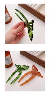 Macro detail of tortoiseshell acetate hair sticks featuring hollow butterfly designs