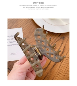 Detail of grey marble pattern acetate hair claw clip with cutout lattice design