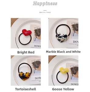 Detail of heart-shaped hair ties in marble black, red, tortoise, and yellow acetate
