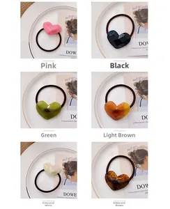 Detail view of heart-shaped resin hair ties in six colors with geometric faceted design