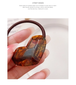 Close-up of heart-shaped tortoiseshell hair tie with France Handmade golden lettering